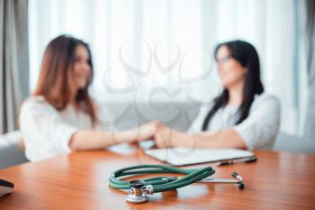 Family doctor examination, wife takes cosultation with specialist. Professional health care