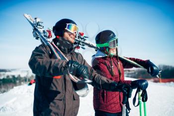 Skiers with skis and poles in hands, winter active sport. Skiing from mountains, extreme lifestyle