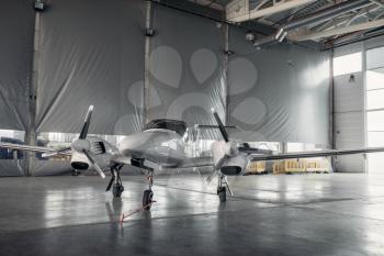 Private turbo-propeller airplane in hangar, plane on inspection before flight.Business air transportation on turboprop plane