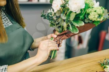 Female florist decorate fresh flower composition. Floral business, bouquet preparation process, materials and tools for decoration on the table