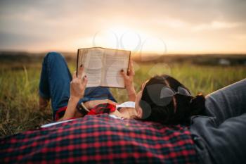 Love couple resting together, picnic in the field. Romantic junket on sunset, man and woman on outdoor dinner,  happy family weekend