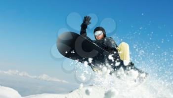 Male snowboarder, dangerous downhill in action, front view. Snowboarding is an extreme winter sport. Man on snowboard in fly
