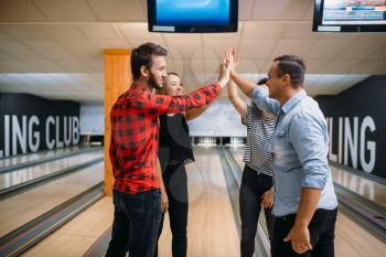 Bowling team joined hands before the competition. Players before strike. Friends playing classical tenpin game in club, active people