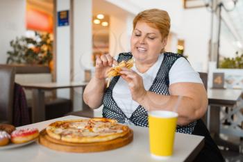 Fatty woman eating pizza in fastfood restaurant, unhealthy food. Overweight female person at the table with junk dinner, obesity problem