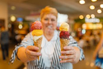 Fat woman holding ice cream in fastfood mall restaurant, unhealthy food. Overweight female person with ice-cream, obesity problem