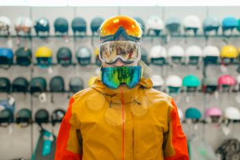 Man at the showcase trying on three masks for ski or snowboarding, front view, shopping in sports shop. Winter season extreme lifestyle, active leisure store, buyers choosing protect equipment