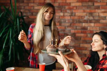 Female university student gets a sweet gift from her friends. Youth at the table in the flat, home party, birthday celebration