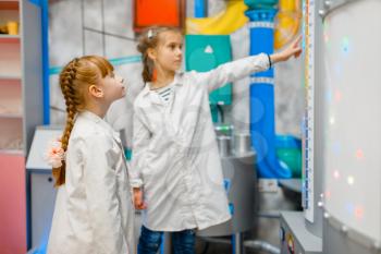 Little children in uniform playing doctors in laboratory, playroom. Kid plays medicine worker in imaginary hospital lab, profession learning, childish dream