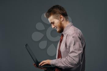 Strong wind blowing on man with laptop, funny emotion. Powerful air flow blows on businessman on black background