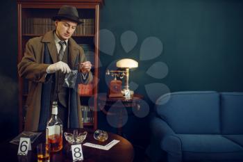 Male detective puts the evidence in a bag at the crime scene, retro style. Criminal investigation, inspector is working on a murder, vintage room interior on background