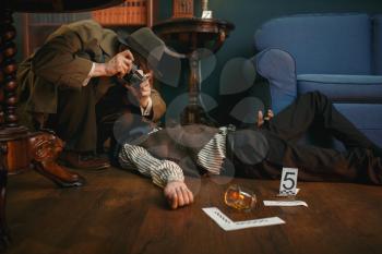 Male detective with photo camera at the crime scene, retro style. Criminal investigation, inspector is working on a murder, vintage room interior on background
