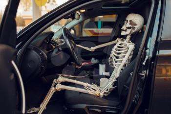 Human skeleton in car with opened door, fueling on gas station, fuel refill. Petrol, gasoline or diesel refuel service, petroleum refueling