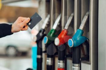 Male person hand takes the gun on gas station, closeup view, fuel filling concept. Petrol fueling, gasoline or diesel refuel service