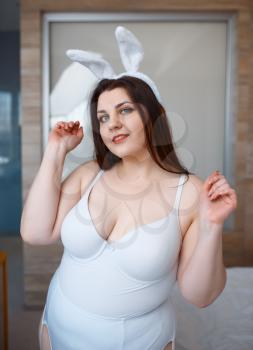 Overweight woman in erotic bunny costume. Sexy overweight girl with big breast, perverse large size lady