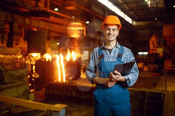 Master in helmet at furnace with liquid metal, steel factory, metallurgical or metalworking industry, industrial manufacturing of iron production on mill