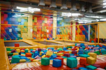 Kids trampoline and soft cubes on playground in entertainment center, nobody. Play area for children indoors, playroom