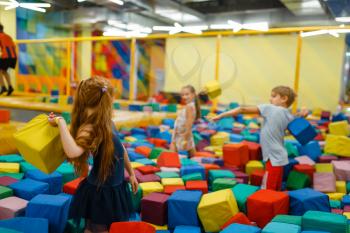 Little children playing with soft cubes, playground in entertainment center. Play area indoors, playroom