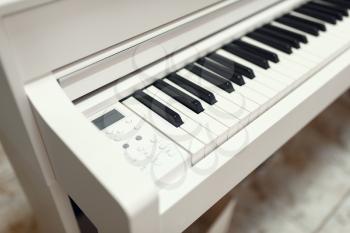 White digital piano in music store, closeup view on keyboard, nobody. Assortment in musical instrument shop, professional equipment for musicians and performers