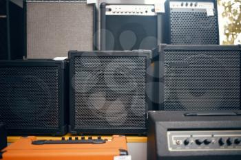 Subwoofer speakers and sound amplifiers on showcase in music store, nobody. Assortment in musical instrument shop, professional equipment for musicians and performers