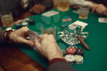 Poker players sitting at the table with cards and chips in casino. Games of chance addiction, gambling house,