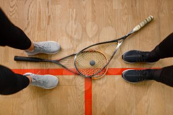 Two female players legs and squash rackets, top view. Girls on training, active sport hobby, fitness workout for healthy lifestyle