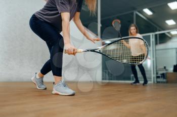 Two female players with rackets, squash game on court. Girls on training, active sport hobby, fitness workout for healthy lifestyle
