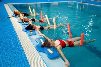 Female swimmers group, aqua aerobics training at the poolside. Women in the water, sport swimming fitness workout in pool