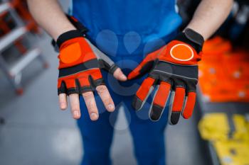 Male worker hands in protective gloves in tool store. Choice of professional equipment in hardware shop, instrument supermarket