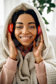 Happy woman in headphones listen to music indoors. Pretty lady in earphones relax in the room, female sound lover resting