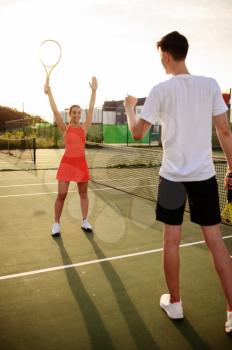 Man and woman play tennis, training on outdoor court. Active healthy lifestyle, people play sport game, fitness workout with racquets