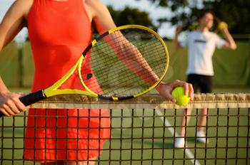 Male and female tennis players with rackets, training on outdoor court. Active healthy lifestyle, people play sport game, fitness workout with racquets