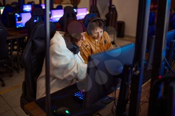 Two gamers having fun in gaming club. Virtual entertainment, e-sport tournament, cybersport lifestyle. Male person leisures in internet cafe