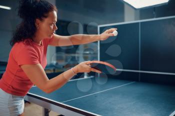 Woman hits ball at the wall, table tennis training, ping pong player. Sportive girl playing table-tennis indoors, sport game with racket, active healthy lifestyle