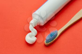 Oral care products, red background, nobody. Morning healthcare procedures concept, toothcare, toothbrush and toothpaste