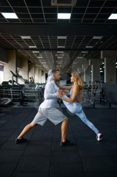 Sportive love couple doing stretching exercise, fitness training in gym. Athletic man and woman on workout in sport club, active healthy lifestyle, physical wellness