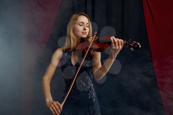 Female violonist with bow and violin, solo concert on stage. Woman with string musical instrument, musician play on viola