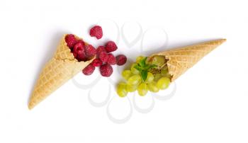 Fresh raspberries and grapes in waffle cones, isolated on white background. Organic vegetarian food, grocery assortment, natural products, healthy lifestyle concept