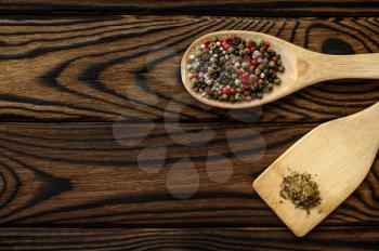 Fragrant spices in a spoon isolated on wooden background, top view. Organic vegetarian food, grocery assortment, natural eco products, healthy lifestyle concept