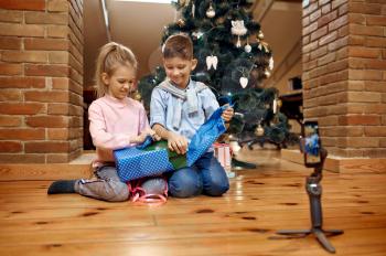 Children bloggers, blog at christmas tree, little vloggers. Kids blogging in home studio, social media for young audience, online internet broadcast