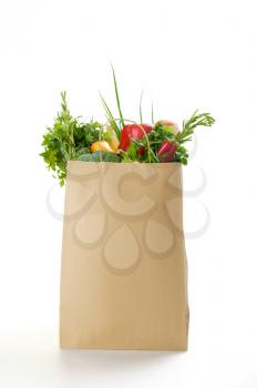 Fresh vegetables and fruits in paper bag, isolated on white background. Organic vegetarian food, grocery products, healthy lifestyle concept