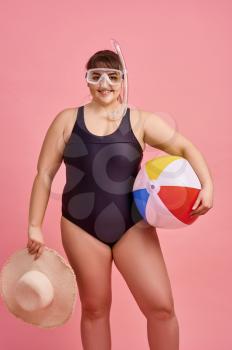 Overweight woman in swimsuit ready for summer vacations, body positive, pink background. Obesity fighting, cheerful female person without complexes, striving for a healthy lifestyle