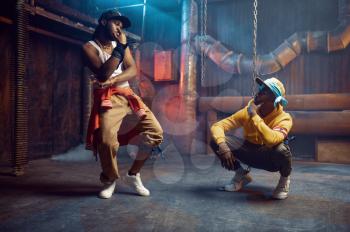 Two rappers dancing, break-dance performing in studio with cool underground decoration. Hip-hop performers, trendy rap singers, break-dancers