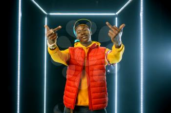 Smiling rapper on the stage with illuminated cube. Hip-hop performer, rap singer, break-dance performing, entertainment lifestyle