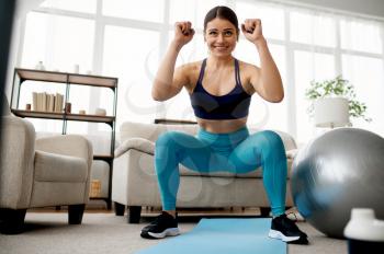 Slim woman doing exercise at home, online pilates training at the laptop. Female person in sportswear, internet sport workout, room interior on background