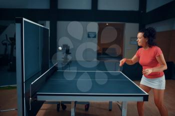 Woman hits the ball at the wall, table tennis, ping pong player. Sportive girl playing table-tennis indoors, sport game with racket, active healthy lifestyle