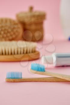 Oral care products, two toothbrush and toothpaste, pink background, nobody. Morning healthcare procedures concept, toothcare