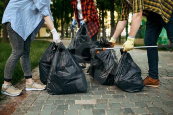 Volunteers holds plastic trash containers in park, volunteering. Male person cleans forest, ecological restoration, eco lifestyle, garbage collection and recycling, ecology care, environment cleaning
