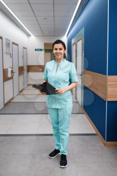 Smiling female doctor poses in clinic. Doctor in uniform, medical worker, medicine and health, professional healthcare in hospital