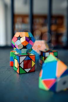 Different puzzle cubes on the table, nobody. Toy for brain and logical mind training, creative game, solving of complex problems