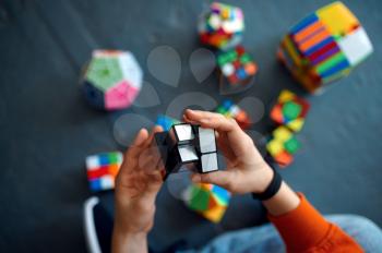Male child play with puzzle cubes. Toy for brain and logical mind training, creative game, solving of complex problems